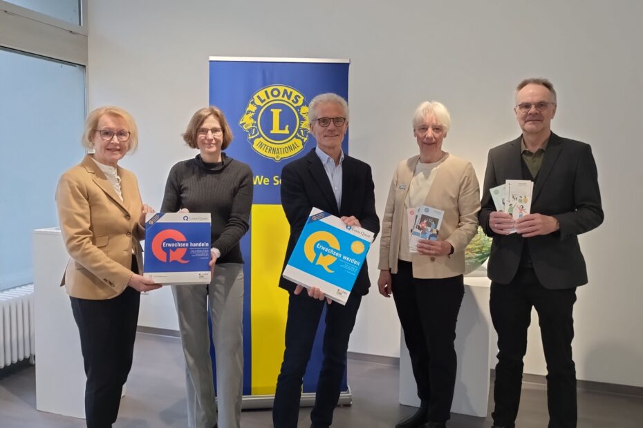 Auf dem Bild sind Vertreter*innen der Lions Clubs WIlla Thorade, des Lions Club Oldenburg-Lappan, des Vorstandes des Förderverein PRO und der Geschäftsführung des PRO zu sehen. Sie halten Aktenordner und Faltblätter zu Lions Quest in Hand. Im Hintergrund ist das RollUp der Lions zu sehen.